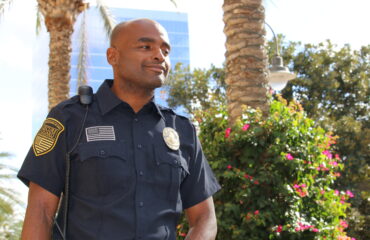 Security guard standing outdoors in uniform, representing the growing need for professional school security guard services in California.