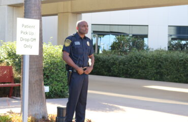 Professional healthcare security guard standing outside a medical facility in California, monitoring patient pickup and drop-off areas to ensure safety and access control.